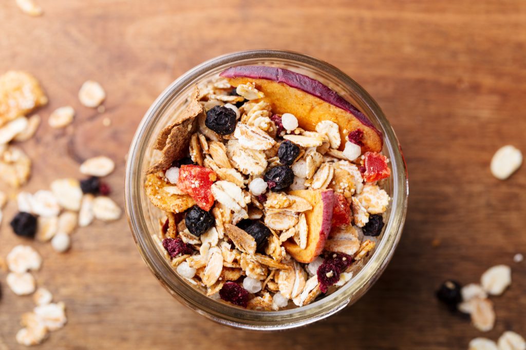 A granola jar with nuts, sliced apples and oats a good source of dietary fiber.