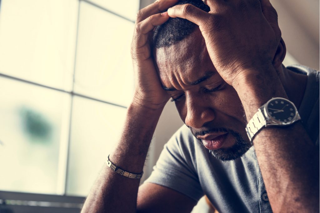 A man looking severely anxious and depressed. He's looks like someone who might have social anxiety.