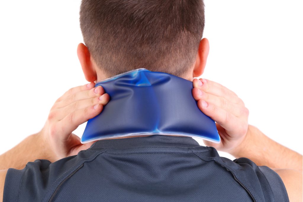 Young man doing hot or cold treatment for neck pain.