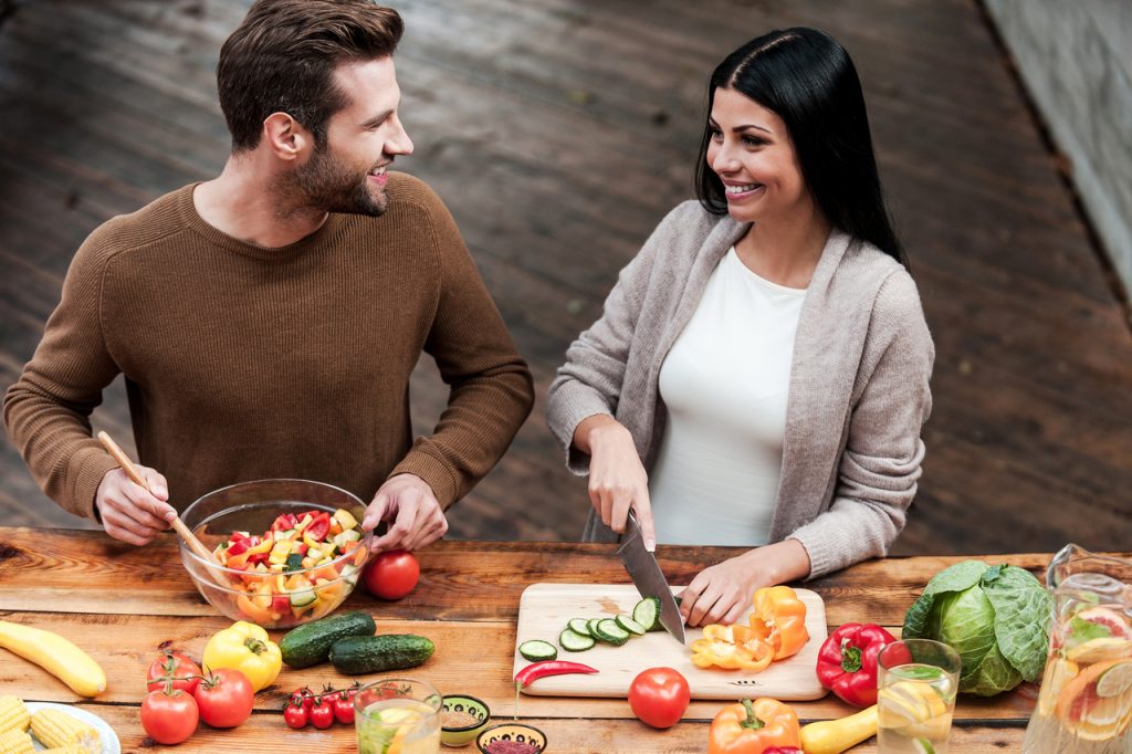 A couple preparing healthy food in the kitchen, adopting the Mediterranean diet, one of the health and wellness food trends.