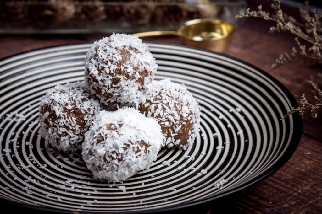 Healthy organic date protein balls with coconut flakes, dried fruits and nuts.