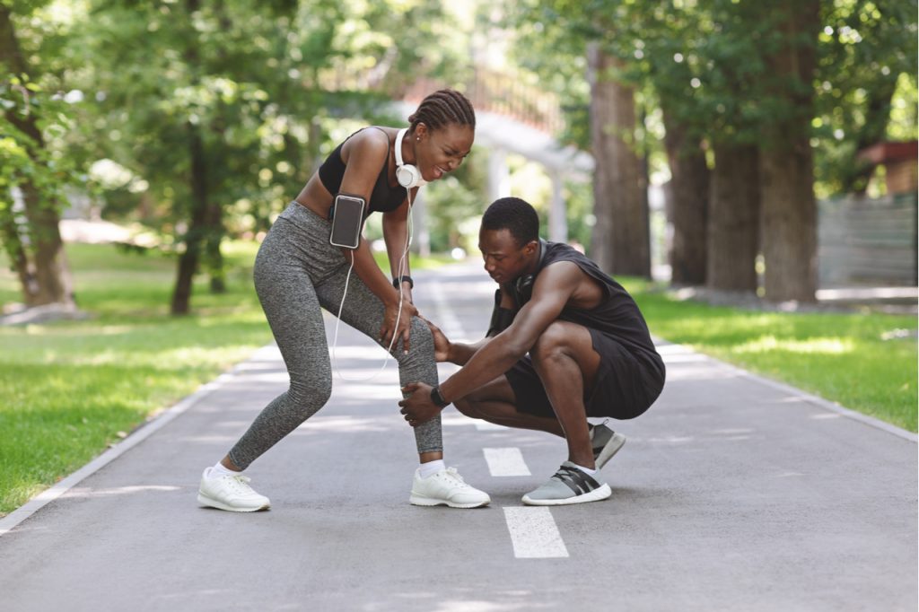 Woman Suffering From Acute Knee Pain During Jogging In Park.