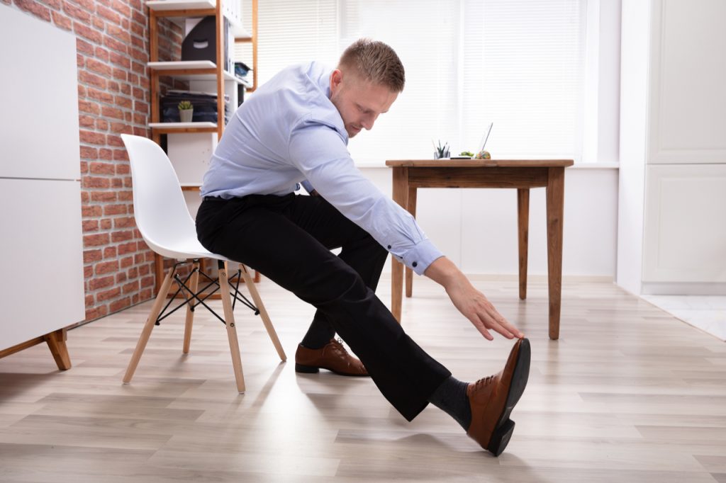Businessman Sitting On White Chair doing chair exercise.