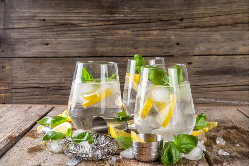 A lemon-based fruity alcoholic drink topped with basil and ice.