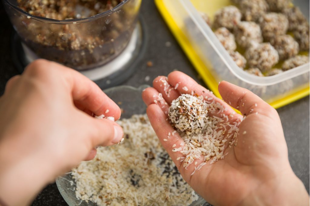 Cooking chocolate protein balls with nuts and peanut butter.