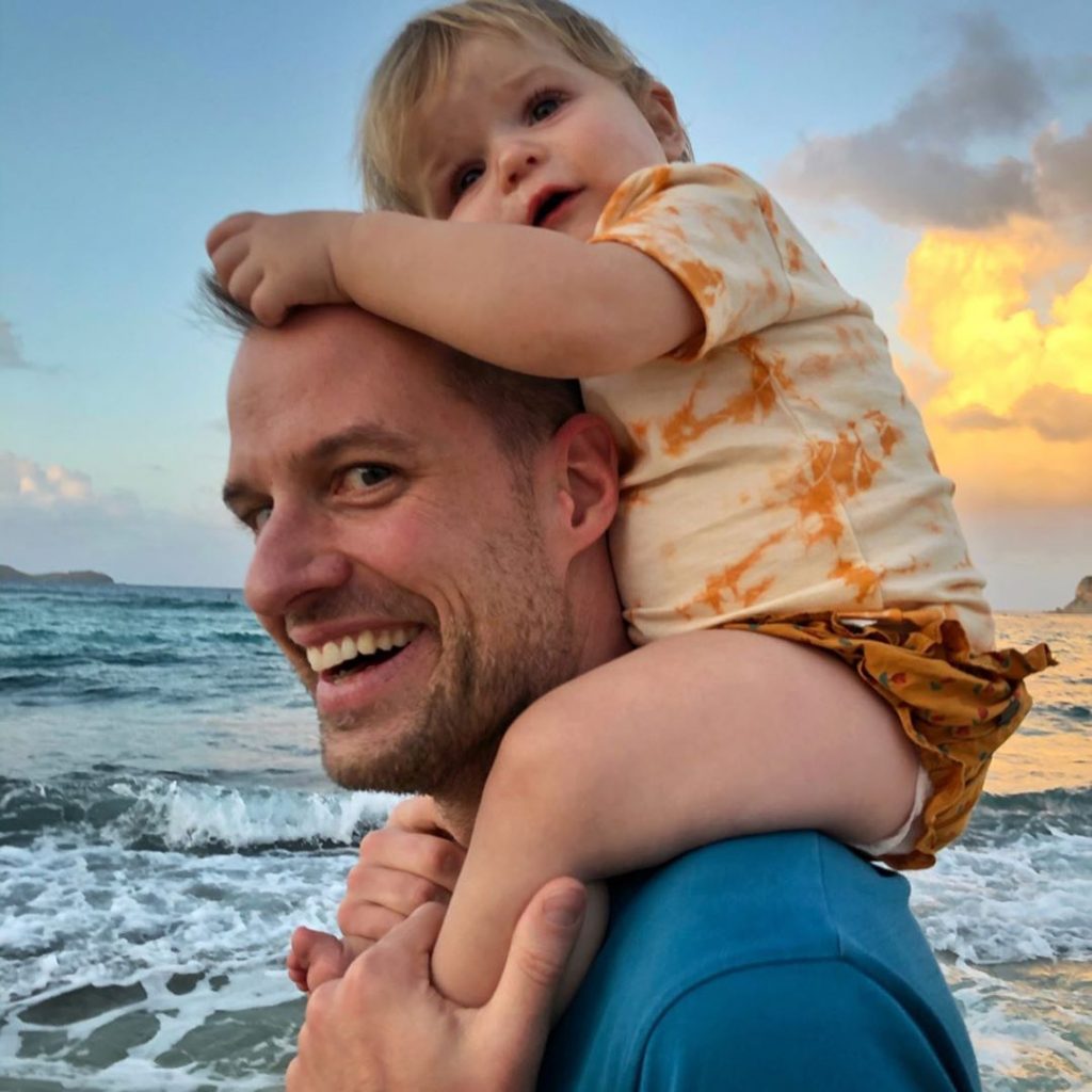 Philippe von Borries at the beach while carrying his daughter Viva on his shoulders.