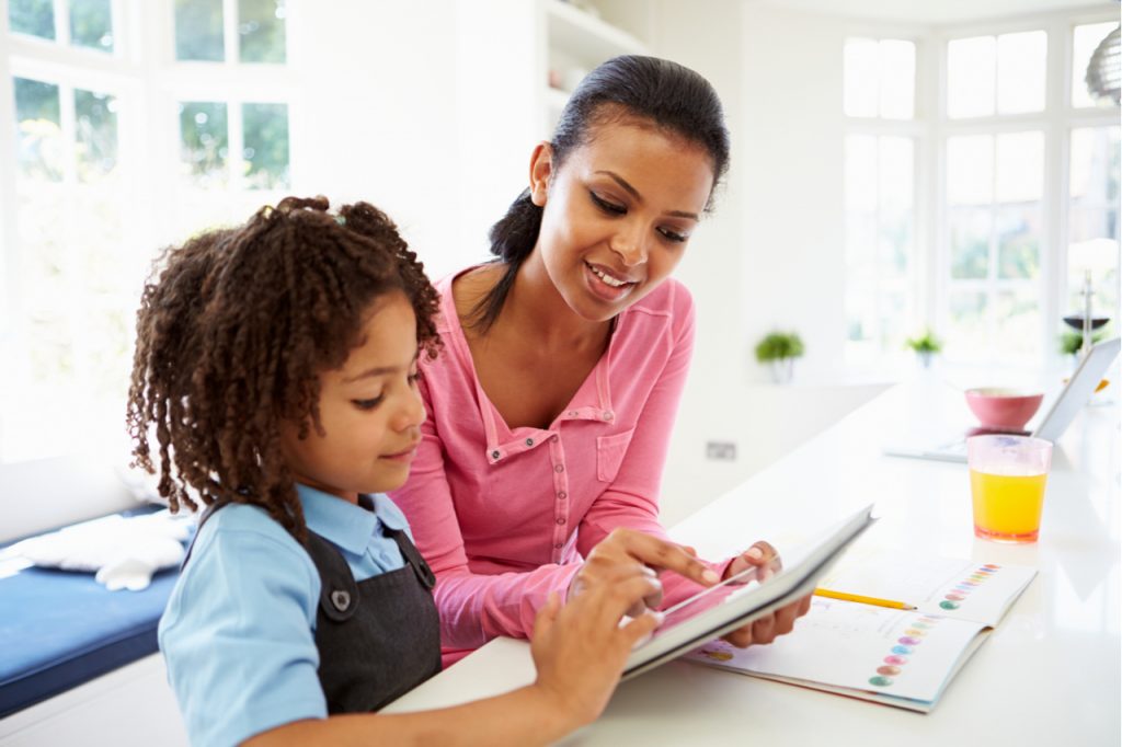 Mother And Child Using Digital Tablet For Homework.