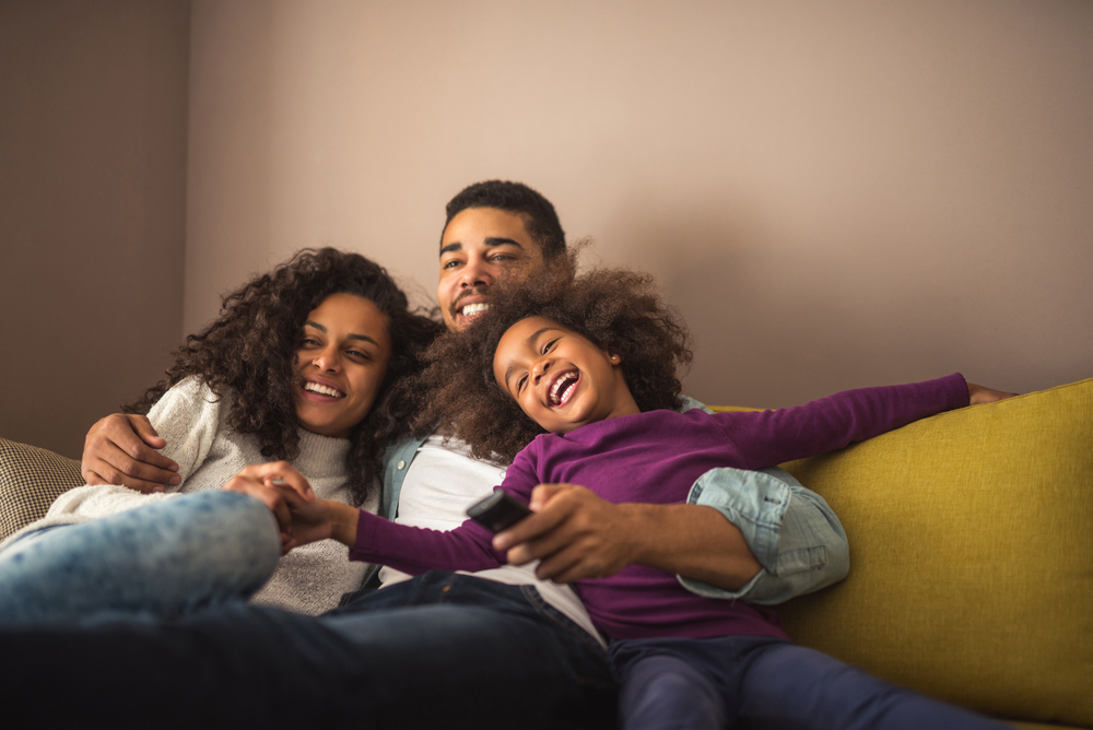 Relaxed african american family watching tv together.