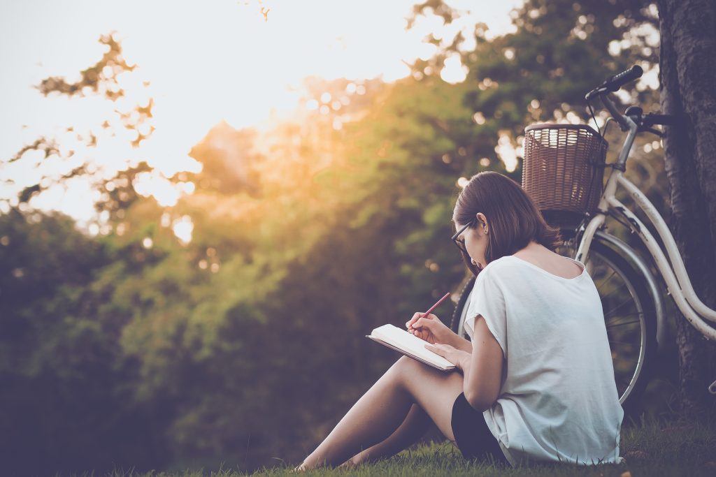 woman writing into her diary, in the park
