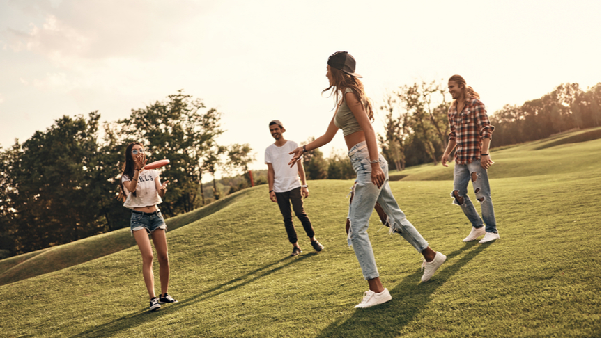 Group of friends playing frisbee at the park.