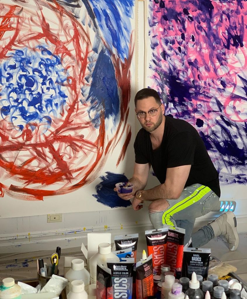 Will Roush, a.k.a. Water Will, painting on a big canvas.