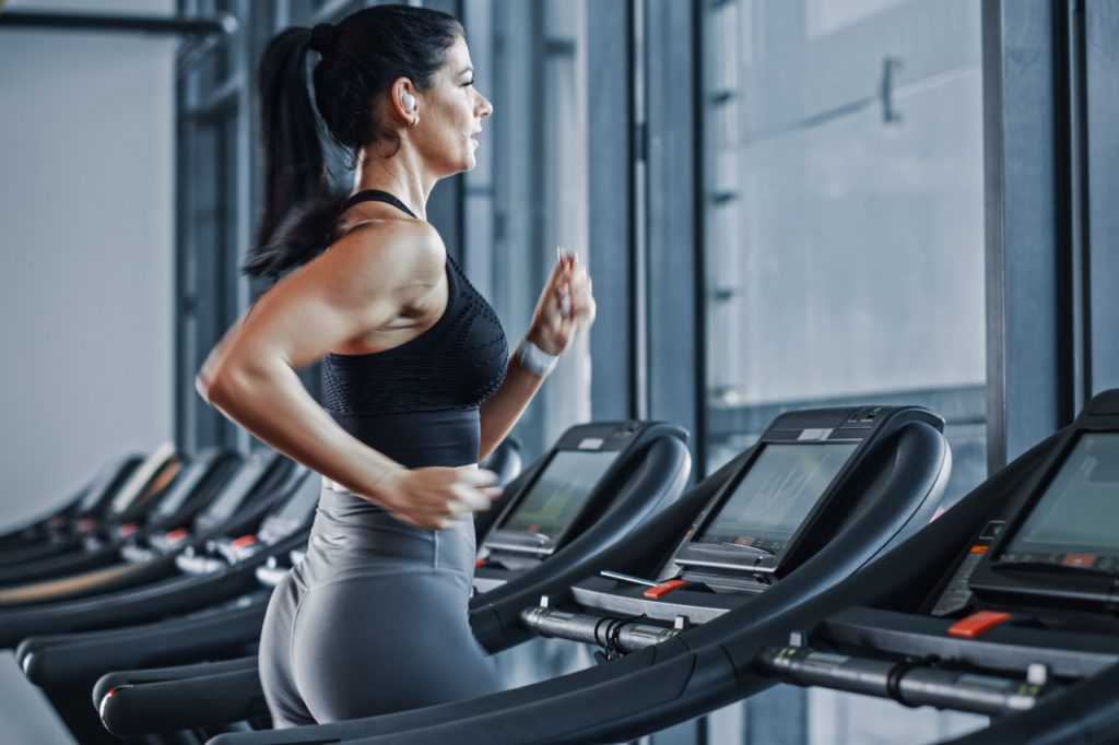 Beautiful Athletic Sports Woman Wearing Wireless Headphones.