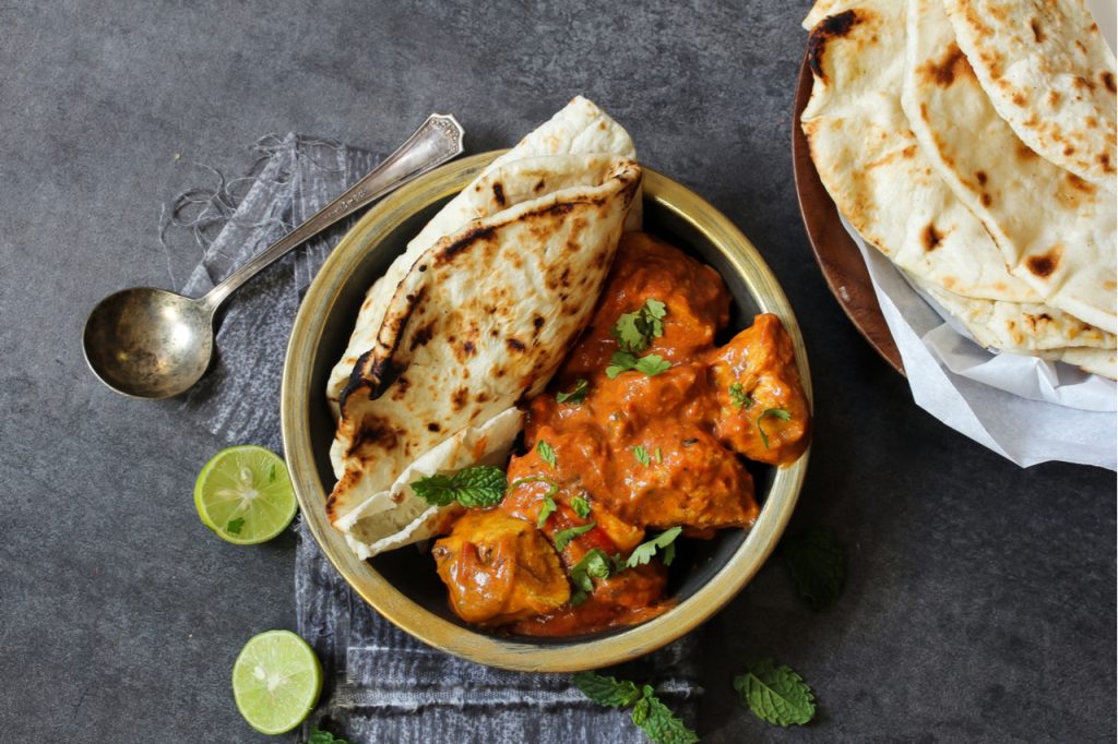 Chicken Tikka Masala, sliced lime and pita bread.