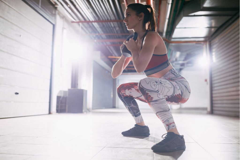 A woman doing goblet squats which is an effective bubble butt workout.