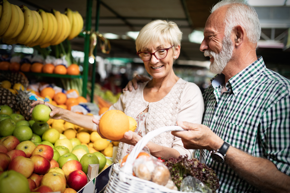 Only the best fruits and vegetables. Beautiful senior couple buying fresh food on market