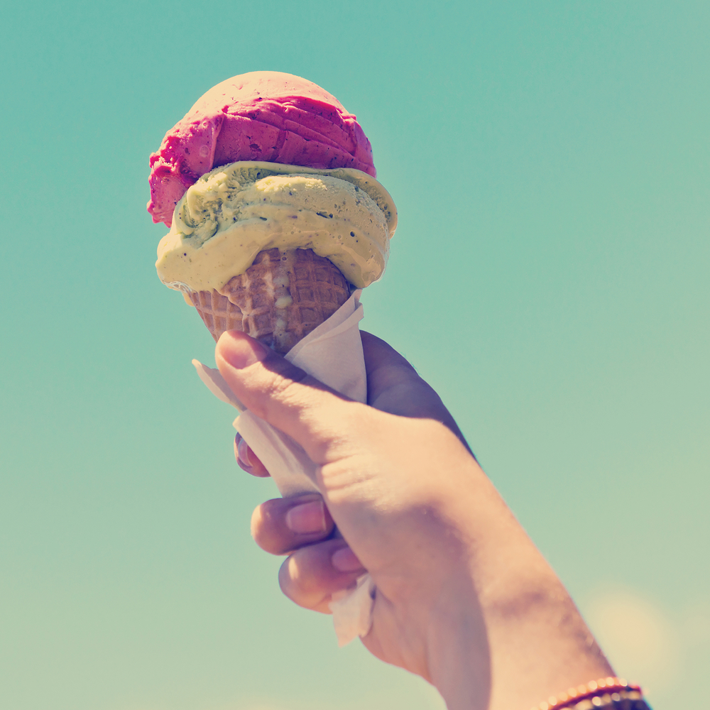 Gelato ice cream cone held up to the hot summer sky with Instagram style filter
