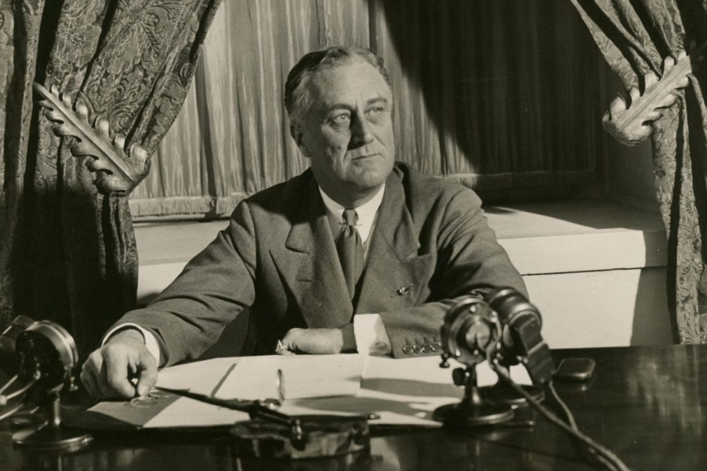 The 32nd US President, Franklin D. Roosevelt signing papers in his office. He was the President who made the Columbus Day an official holiday. What is Columbus Day?