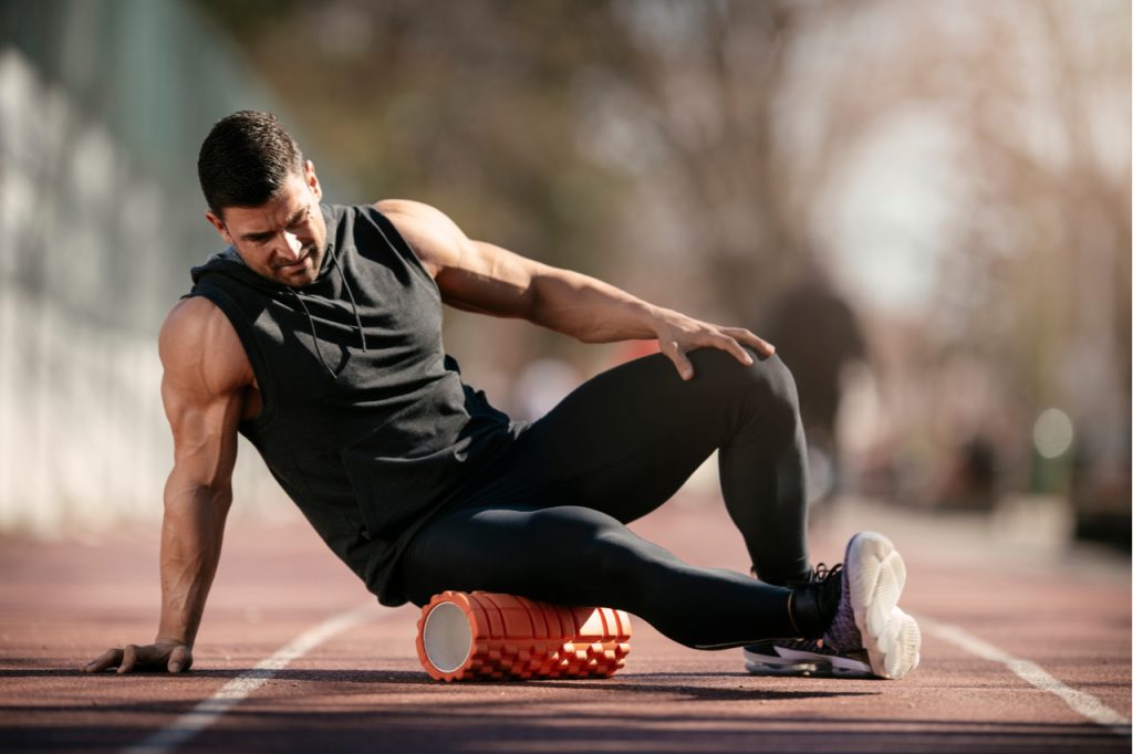 Athlete stretches using TriggerPoint GRID Foam Roller.