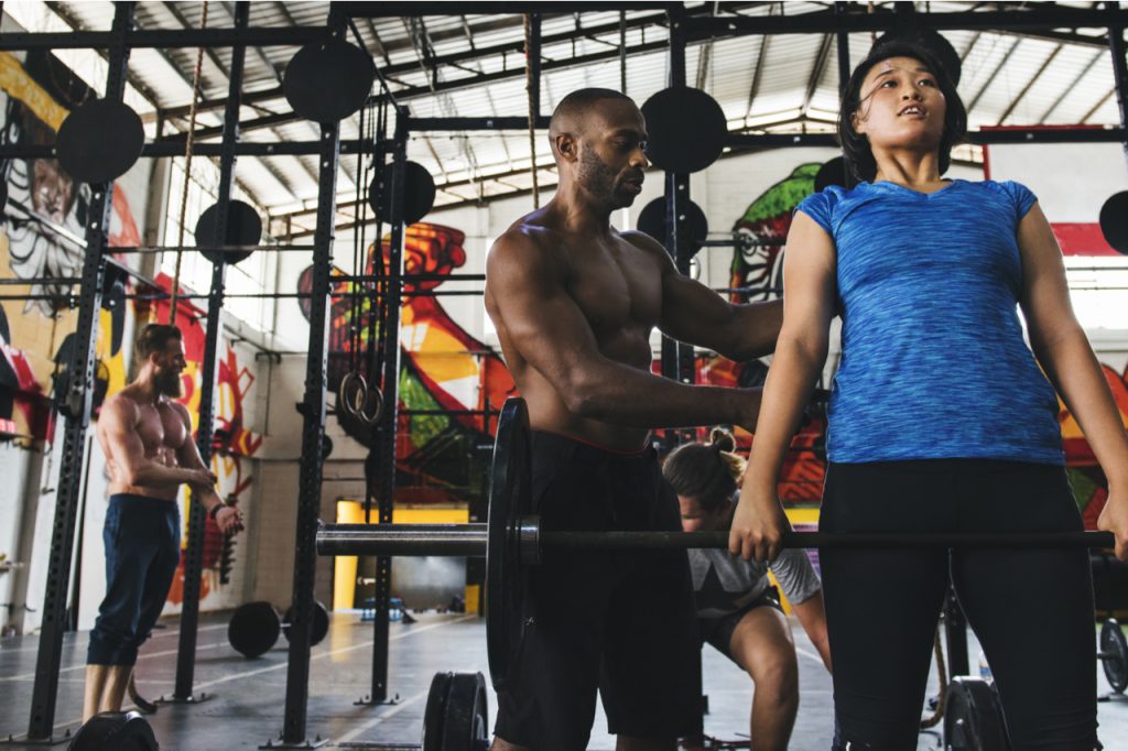 Multiracial people doing workout routine with gym membership.