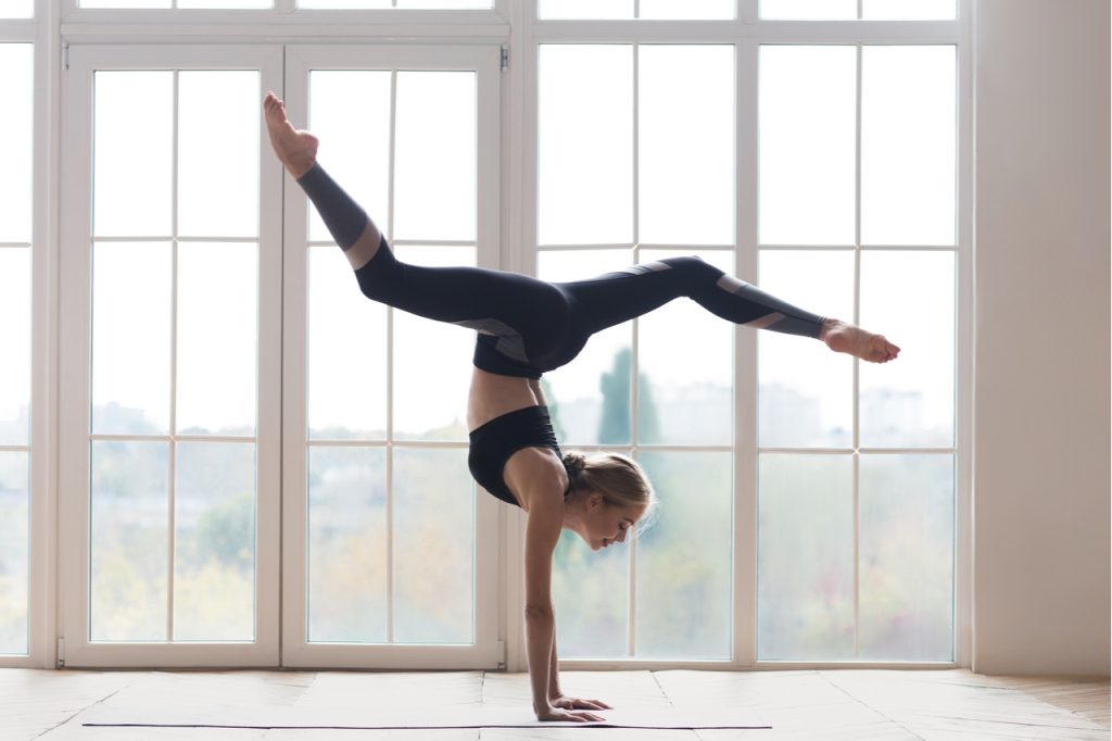 Young sporty flexible woman practicing yoga, wearing best workout clothes.