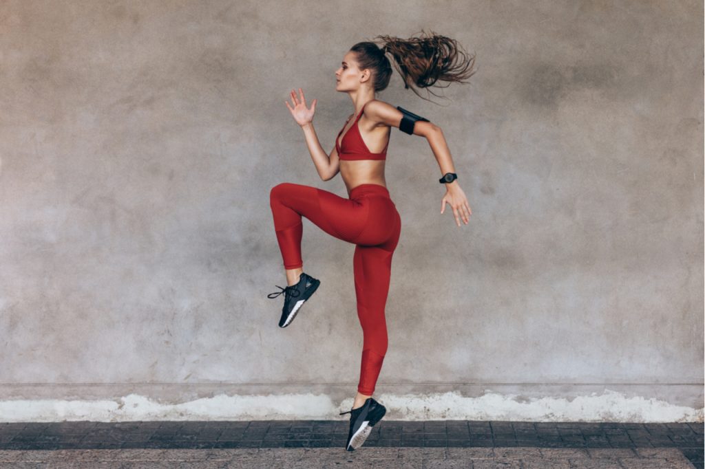 Sportswoman jumping and stretching.