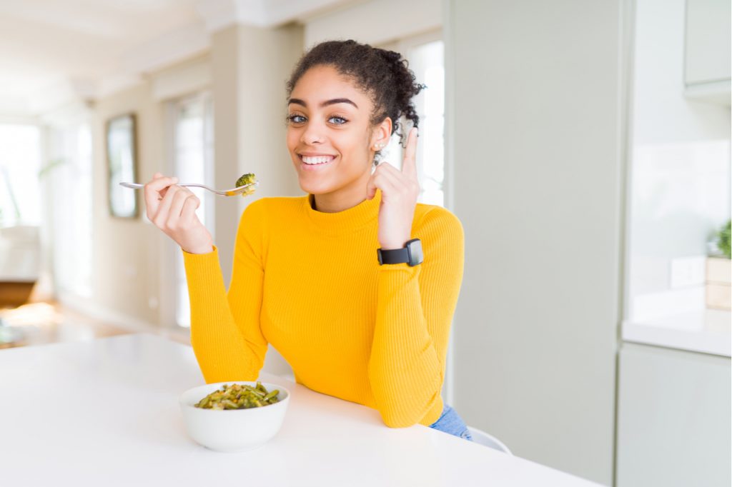 Woman eating healthy green vegatables.