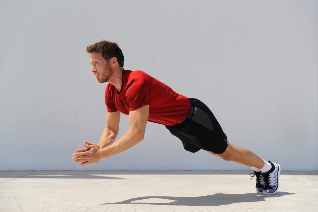 Clap pushup fitness man doing plyometrics push-up exercises explosive workout for muscles training.