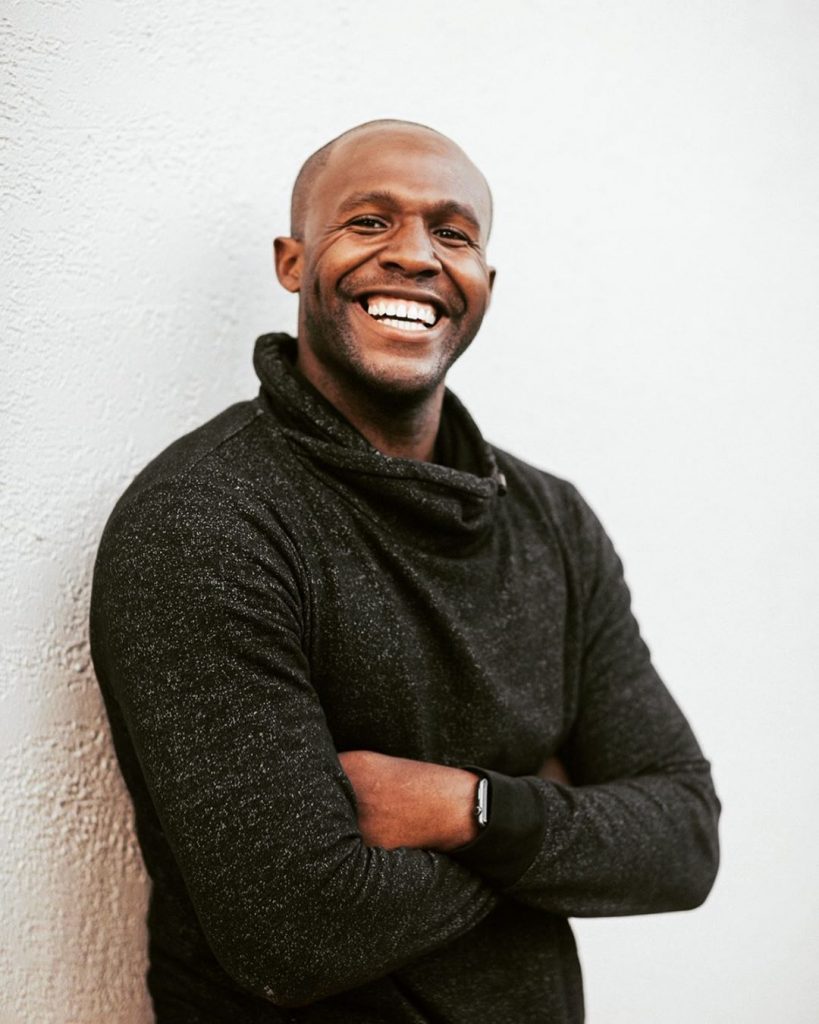 Soji James' home page photo on his website SojiFit. wearing a dark gray shirt.