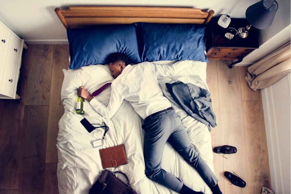 Business man drunk falling asleep as soon as he came back home in need of hangover remedy.