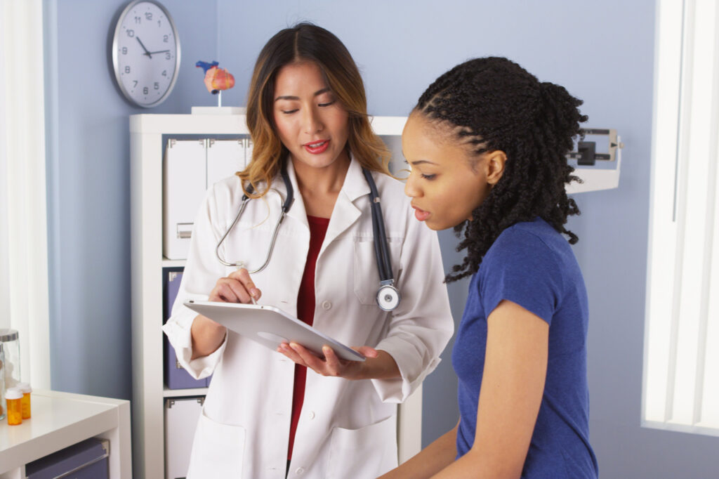 Patient explaining issues to doctor using tablet.