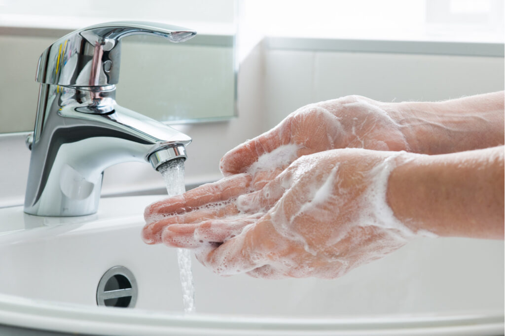 Hygiene concept. Washing hands with soap under the faucet with water