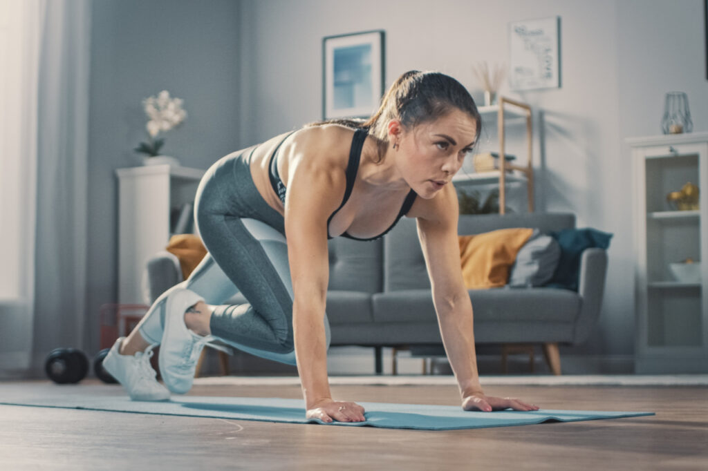 Woman doing mountain climber exercise in her living room.