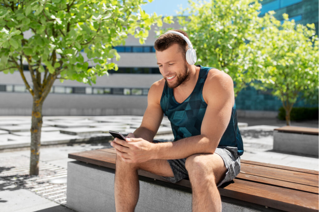 A sporty looking man listening to a podcast about fitness. Replacing negativity. Also, saying thank you to people attracts more positive energy.