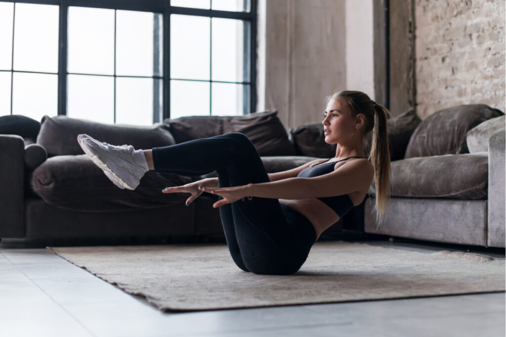Slim sporty girl doing abs workout at home.