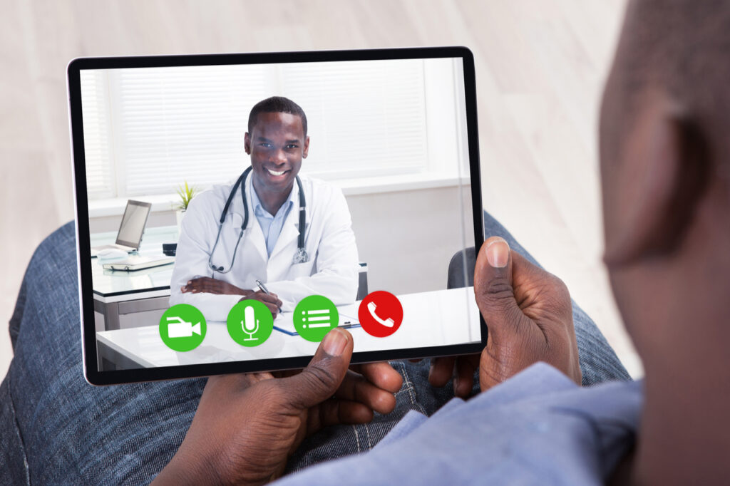 An African Man Doing Video Conference With Doctor On Digital Tablet