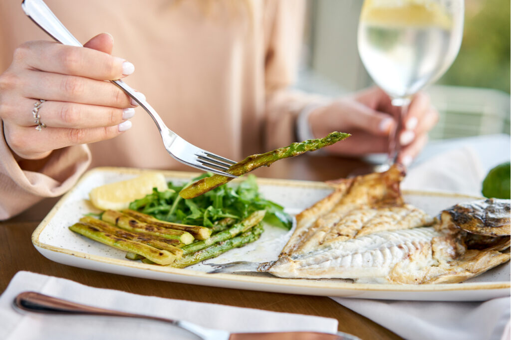 Lunch in a restaurant, a woman eats healthy spring recipes.