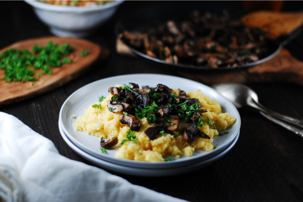 Creamy polenta with fried mushrooms and fresh herbs for lunch.