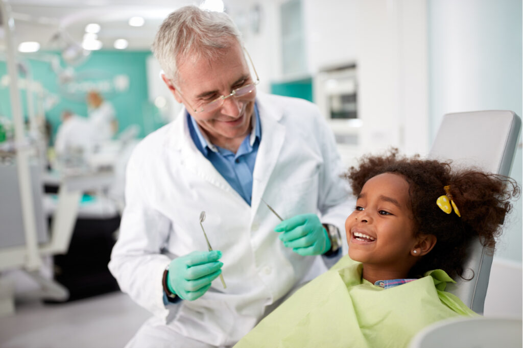 Happy kid on dental chair after repairing tooth