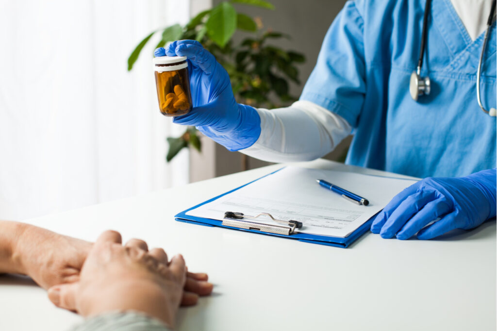 Healthcare professional prescribing treatment therapy to elderly senior citizen.