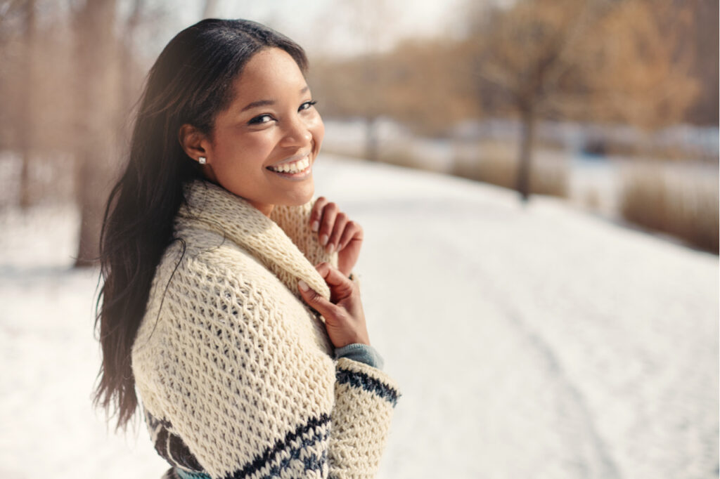 Beautiful young woman in the snow in winter.