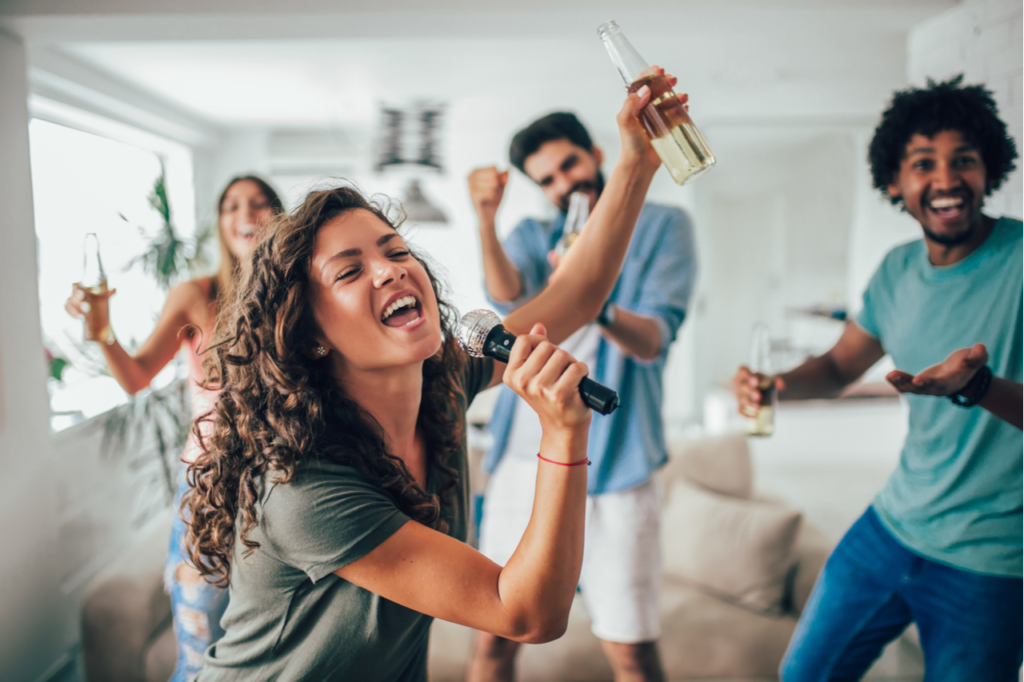 Group of friends playing karaoke at home.