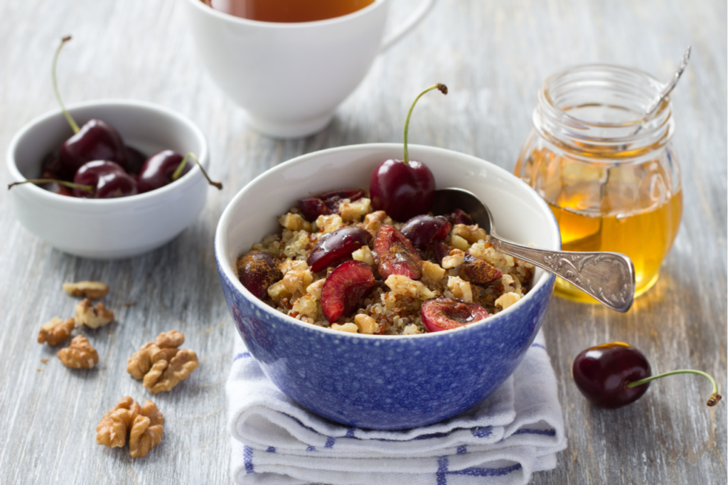 Healthy Pumpkin Spice Breakfast Quinoa Recipe in a bowl topped with cherries an nuts a fall breakfast ideas.