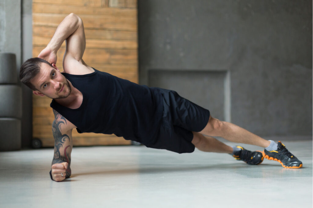 Fit man doing side plank.