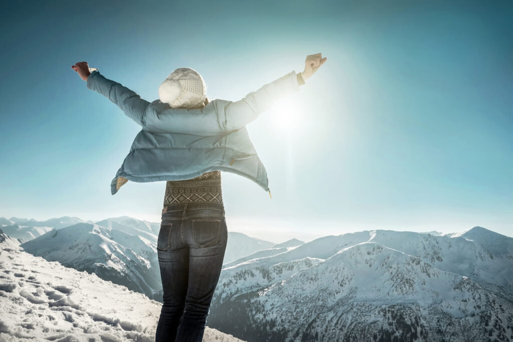 Mental health tips includes relaxing on the top of mountain at sunny winter day to help with.