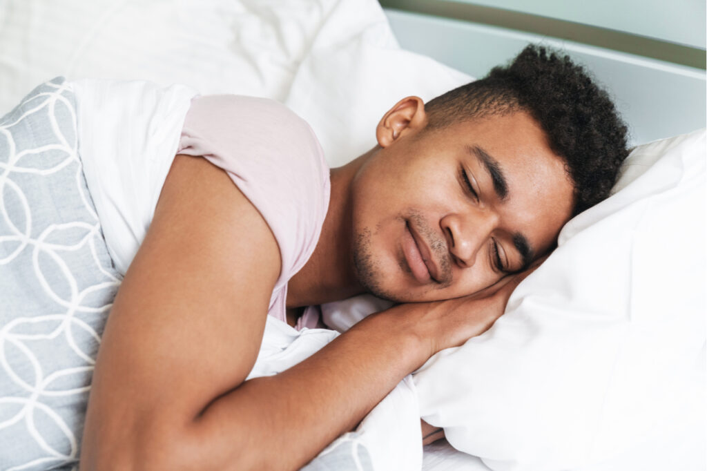 Guy in the morning in bedroom lies in bed.