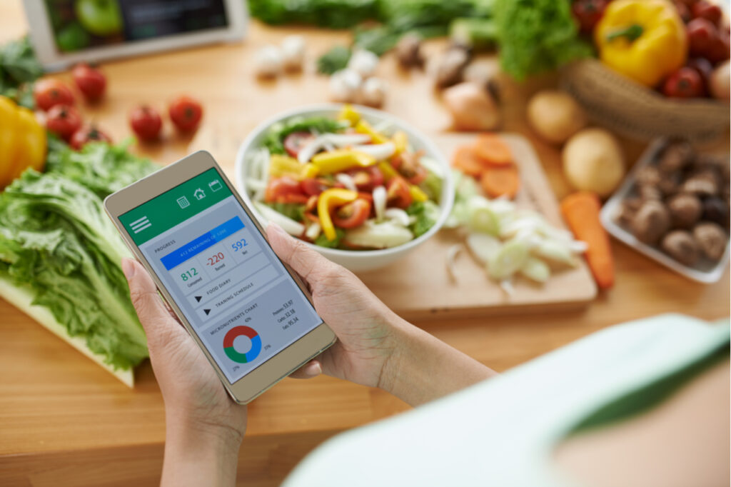 Woman using calorie counter application on her smartphone.