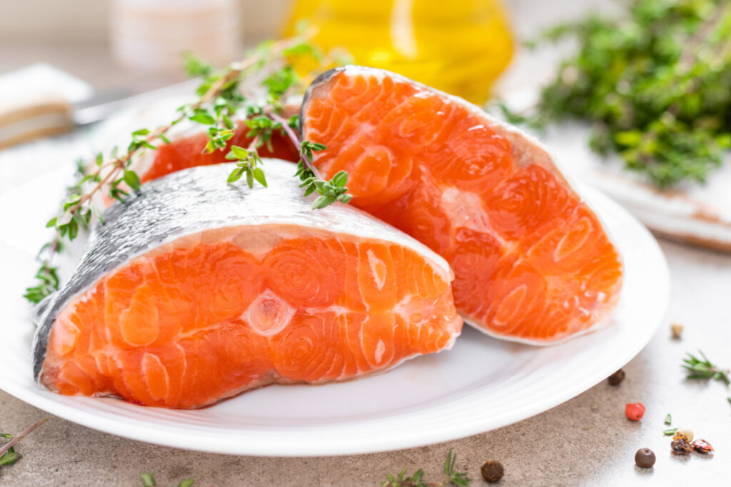 Fresh raw salmon fish steaks on white kitchen for National Nutrition Month.