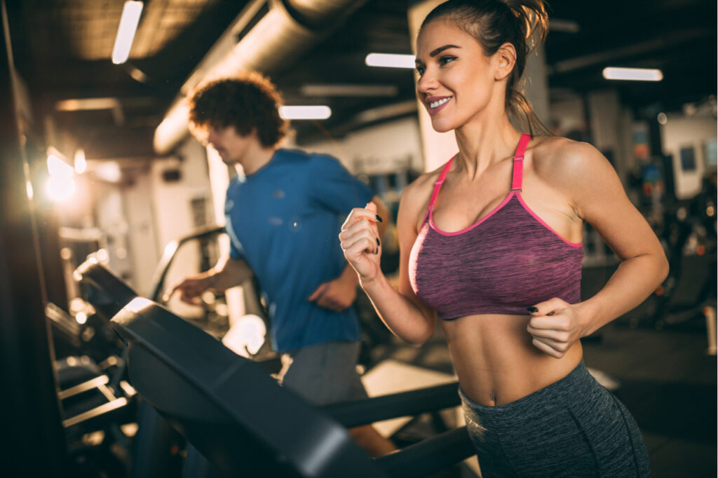 Horizontal photo of attractive woman jogging on treadmill at health club for kidney health.