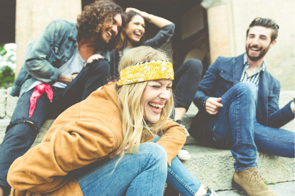 Group of four friends laughing out loud outdoor.