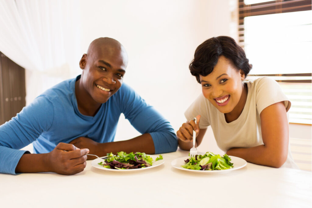 Couple eating healthy salad for lunch counting macros.